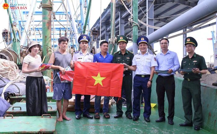 Lực lượng Biên phòng Triệu Vân và lực lượng CS Biển tặng cờ Tổ quốc cho các chủ tàu cá, ngư dân trên địa bàn xã Nam Cửa Việt