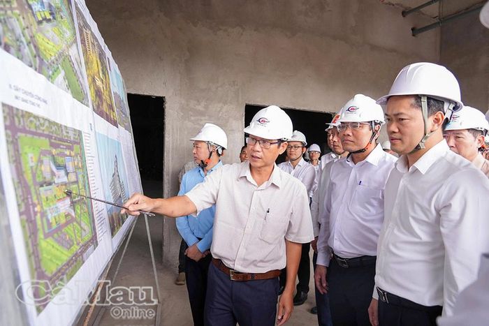 Thứ trưởng Thường trực Bộ Y tế Vũ Mạnh Hà (bìa phải) và Phó Chủ tịch UBND tỉnh Cà Mau Ngô Vũ Thăng (thứ hai từ phải sang) nghe báo cáo tiến độ thi công Dự án Bệnh viện Đa khoa Cà Mau quy mô 1.200 giường.