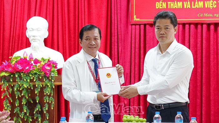 Bác sĩ CKII Trương Minh Kiển, Giám đốc Bệnh viện Sản - Nhi Cà Mau, tiếp nhận phần quà từ Thứ trưởng Thường trực Bộ Y tế Vũ Mạnh Hà trao cho bệnh nhi đang điều trị tại bệnh viện.