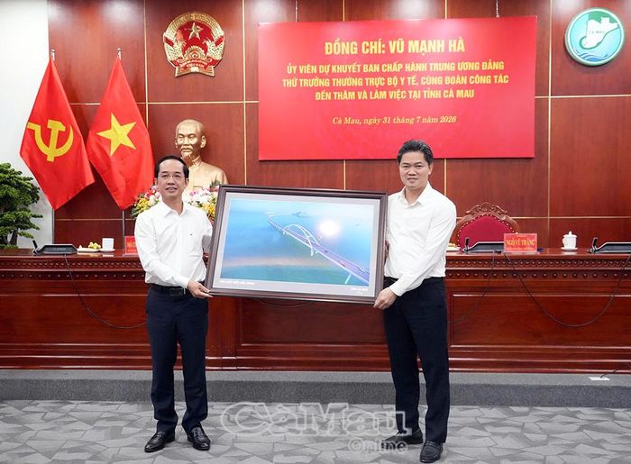  Dịp này, Phó Bí thư Tỉnh ủy, Chủ tịch Ủy ban MTTQ Việt Nam tỉnh Cà Mau Hồ Thanh Thủy trao tặng Thứ trưởng Thường trực Bộ Y tế Vũ Mạnh Hà bức tranh lưu niệm công trình cầu vượt biển ra đảo Hòn Khoai.
