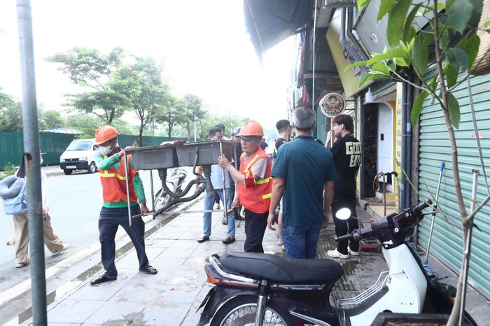 Ban Chỉ đạo 197 phường Từ Liêm tuyên truyền, yêu cầu các hộ kinh doanh tự giác tháo dỡ công trình, vật dụng lấn chiếm vỉa hè trên đường Hồng Đô. Ảnh:NT