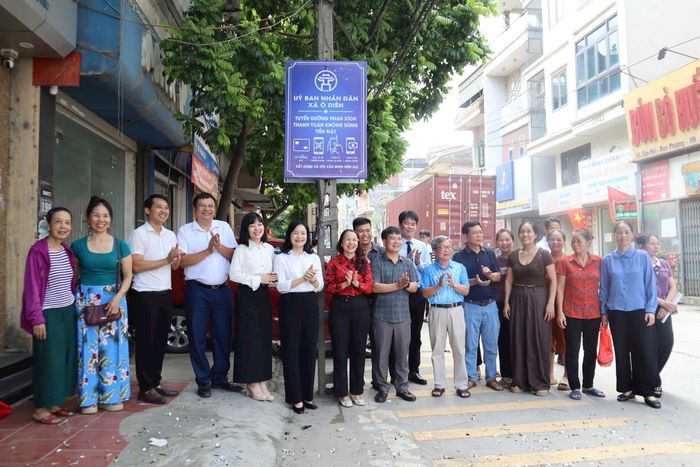 Các đại biểu và tiểu thương xã Ô Diên ra mắt mô hình tuyến đường Phan Xích thanh toán không dùng tiền mặt. Ảnh: NM