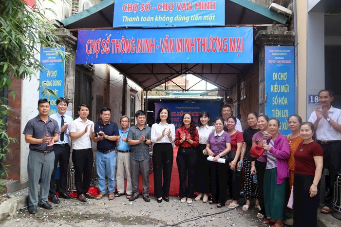 Các đại biểu và tiểu thương xã Ô Diên ra mắt mô hình Chợ số thông minh - Văn minh thương mại tại chợ Gối. Ảnh: NM