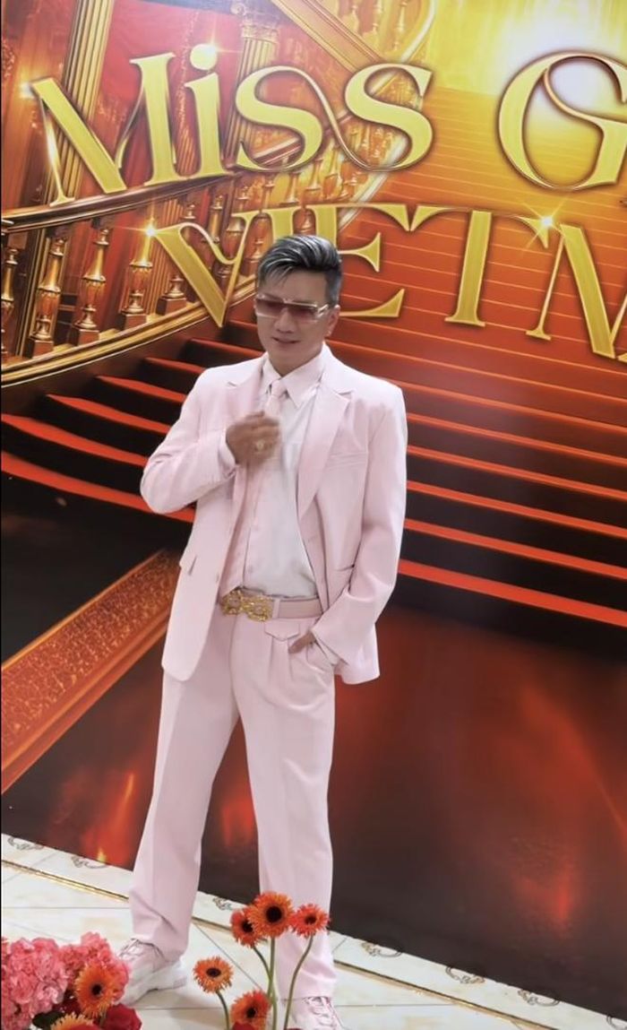 Đàm Vĩnh Hưng gây sốt khi xuất hiện nổi bật trên thảm đỏ với bộ suit màu hồng phấn thanh lịch, kết hợp cùng kính mát đồng điệu và mái tóc tạo kiểu cá tính. Nam ca sĩ ghi điểm với thần thái tự tin, góp phần khuấy động không khí chung kết Miss Grand Vietnam 2026.