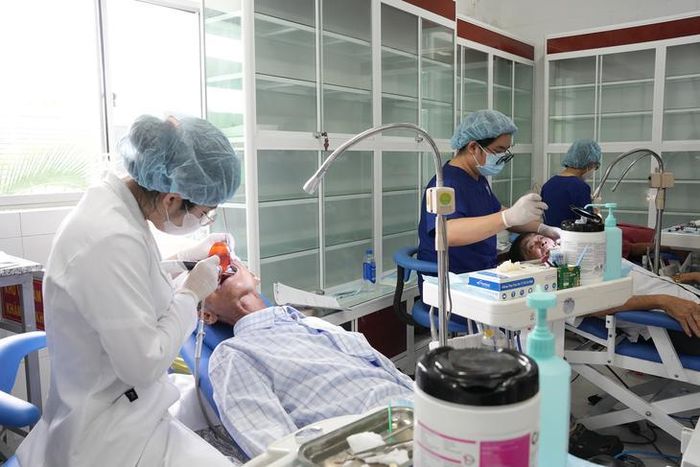 Bác sĩ thăm khám, chăm sóc răng miệng giúp bà con ở xã Năm Căn. Ảnh: Văn Khoa.