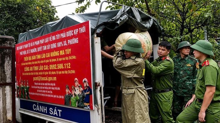Lực lượng Công an xã Bát Xát hỗ trợ người dân thôn Bản Vai di chuyển tài sản ra khỏi khu vực có nguy cơ sạt lở. Ảnh: TTXVN phát