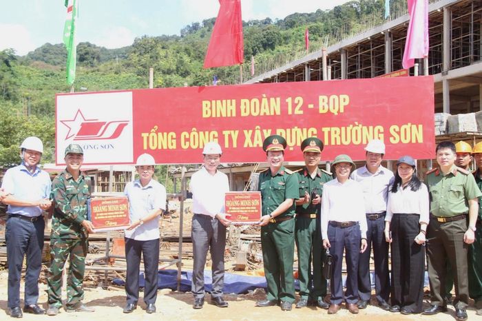 Bộ trưởng Hoàng Minh Sơn (thứ 4 từ trái sang) và Phó Chủ tịch UBND TP Trần Anh Tuấn (thứ 3 từ trái sang) tặng quà động viên đơn vị thi công trường nội trú liên cấp biên giới Hùng Sơn. (Ảnh chụp ngày 29- 5-2026).