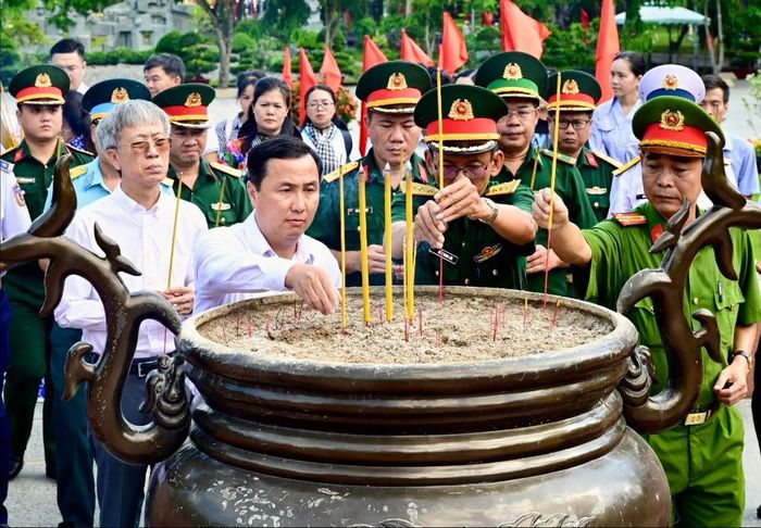 Đồng chí Lê Hoàng Hải cùng các đại biểu dâng hương tại Nghĩa trang Hàng Dương. Ảnh: VĂN MINH