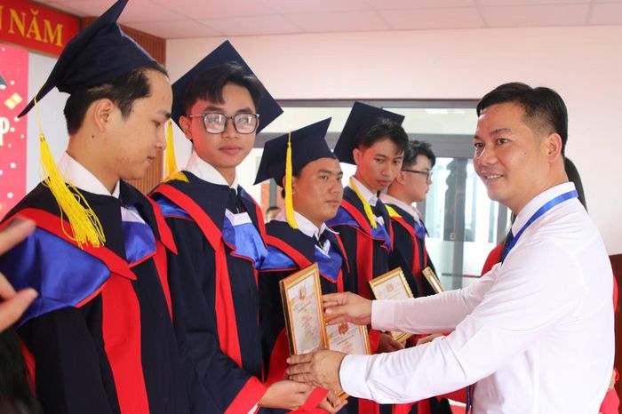 Lãnh đạo nhà trường tặng giấy khen cho các sinh viên có thành tích tốt trong học tập. (Ảnh: Thế Hùng)