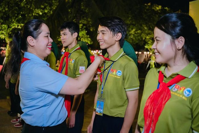 Chị Trịnh Thị Hiền Trân - Phó Bí thư Thành Đoàn, Chủ tịch Hội đồng Đội TPHCM, đeo khăn quàng đỏ cho các thành viên tham gia hành trình.