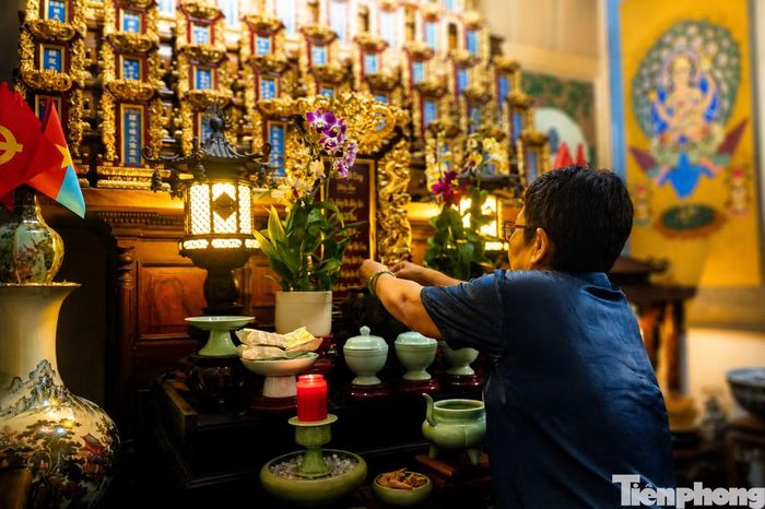 Bà Tuyết thắp hương tại khu vực thờ tự liệt sĩ Ngô Văn Cáng và những người đồng đội là chiến sĩ biệt động của ông. (Ảnh: Nguyễn Tiến)