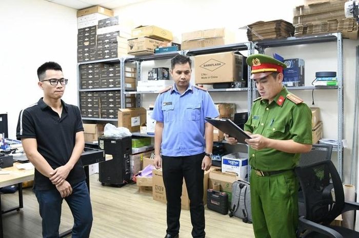 Kiểm sát viên kiểm sát việc thi hành Lệnh khám xét nơi làm việc đối với Khuất Tiến Minh, Giám đốc Công ty TNHH MTV giải pháp công nghệ Tek- Solution. Ảnh: CAPT