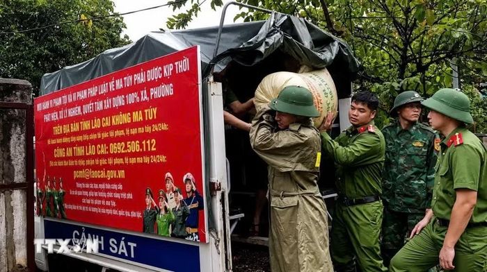 Cán bộ, chiến sỹ Công an xã Bát Xát phối hợp vận chuyển tài sản của người dân đến nơi an toàn. (Ảnh: TTXVN phát)