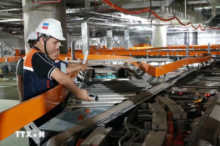Người lao động kiểm tra, chạy thử các kết cấu của hệ thống xử lý hành lý nhà ga hành khách sân bay Long Thành. (Ảnh: Công Phong/TTXVN)