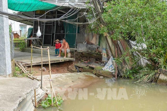 Tuyến đường bê tông qua khu vực đông dân cư ở gần bến phà Mang Cá (xã Đại Hải) bị chia cắt hoàn toàn do sạt lở. Ảnh: Thanh Liêm - TTXVN