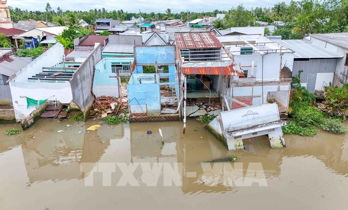 Những căn nhà bị sạt lở làm sụp hơn phân nửa xuống sông tại ấp Mang Cá, xã Đại Hải. Ảnh: Thanh Liêm - TTXVN