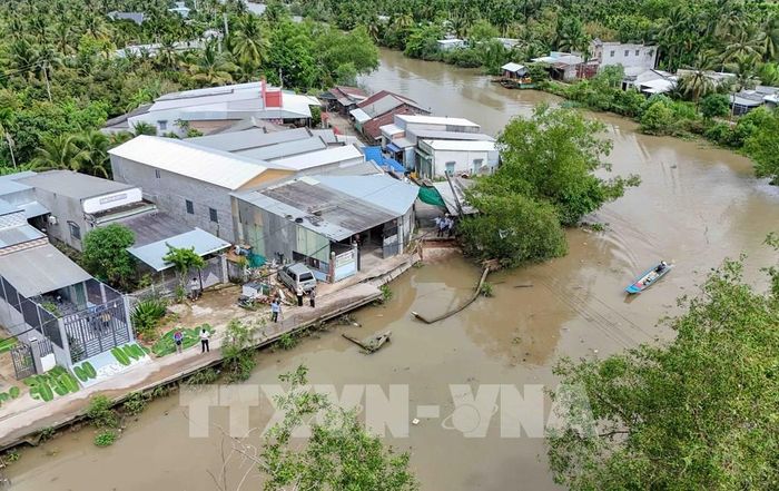 Con đường bê tông ven rạch Mang Cá bị sạt lở, giao thông qua khu vực dân cư đông đúc bị chia cắt. Ảnh: Thanh Liêm - TTXVN