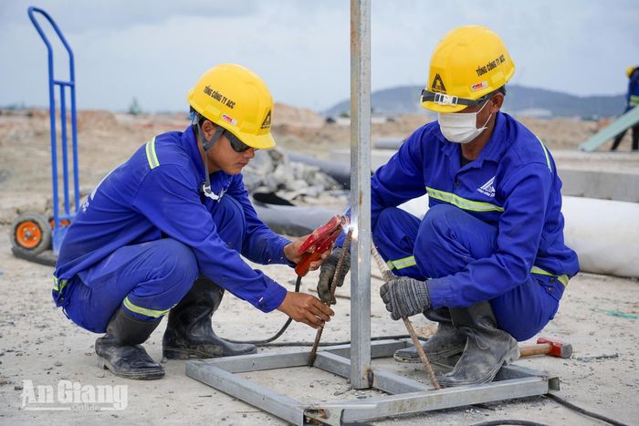 Hai công nhân hàn cố định khung thép tại công trường thuộc Dự án đầu tư mở rộng Cảng hàng không quốc tế Phú Quốc. Ảnh: THỤY DU