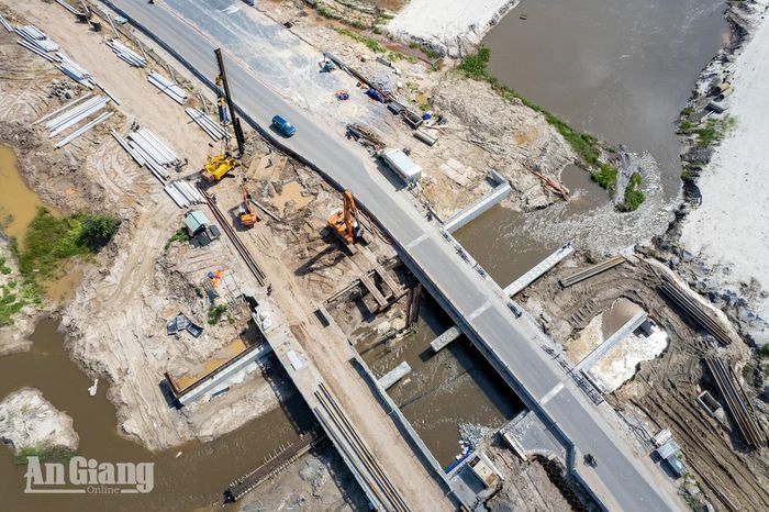 Đoạn cầu vượt ngang kênh thuộc Dự án Tuyến tàu điện đô thị đoạn 1 nhìn từ trên cao, mặt cầu đã đổ bê tông, các thiết bị thi công vẫn hoạt động bên dưới. Ảnh: THỤY DU.