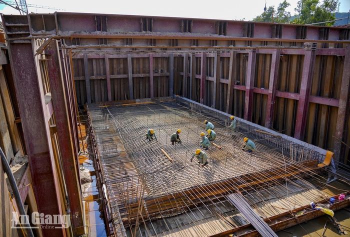 Công nhân buộc cốt thép bên trong hố móng sâu của ga ngầm thuộc Dự án Tuyến tàu điện đô thị đoạn 1, hệ thống ván khuôn thép bao quanh. Ảnh: THỤY DU.
