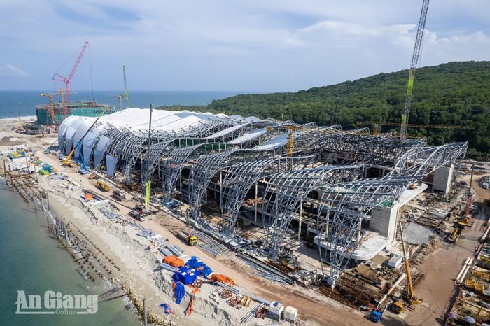 Hệ khung thép mái vòm của tại dự án Trung tâm tổ chức hội nghị APEC và các công trình chức năng đang được lắp dựng, các cẩu tháp và cẩu bánh xích hoạt động dọc công trình sát mép biển. Ảnh: THỤY DU.