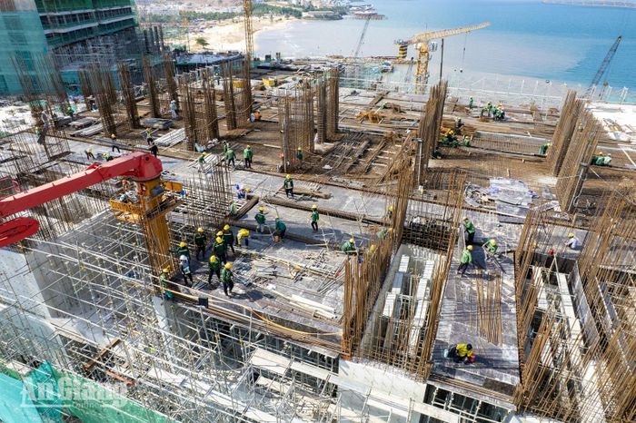 Công nhân thi công cốt thép trên sàn công trình, hàng chục kỹ sư, công nhân mặc đồng phục, đội mũ bảo hộ làm việc giữa rừng thép chờ đổ bê tông. Ảnh: THỤY DU.