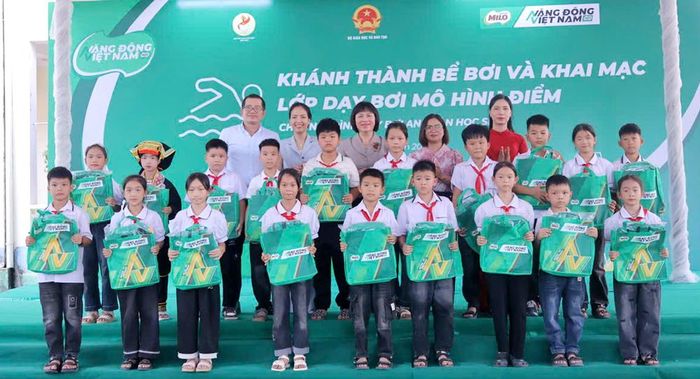 Các đại biểu trao đồ dùng học bơi cho học sinh Trường Tiểu học Đồng Vương.