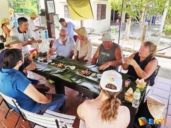 Du khách nước ngoài thưởng thức các sản vật đặc trưng của địa phương tại Lễ hội sông Cổ Cò lần thứ nhất vào năm 2024. Ảnh: ĐOÀN HẠO LƯƠNG