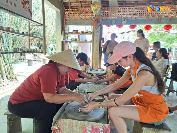 Du khách quốc tế trải nghiệm làm gốm tại làng gốm Thanh Hà. Ảnh: THU HÀ