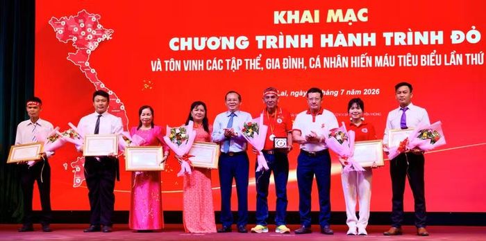 Anh Trần Duy Nhất (bìa phải) và anh Võ Thanh Hưng (thứ 2 từ trái sang) được biểu dương tại lễ khai mạc Hành trình đỏ năm 2026. Ảnh: N.M