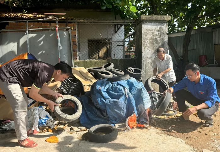 Các lực lượng kiểm tra, xử lý các vật dụng phế thải có khả năng đọng nước để ngăn ngừa lăng quăng phát triển. Ảnh: PHÙNG QUỲNH.