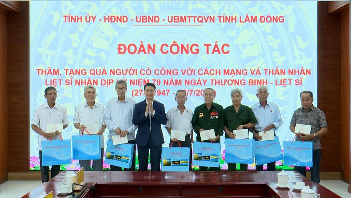 Đồng chí Bùi Huy Thành, Trưởng Ban Tuyên giáo và Dân vận Tỉnh ủy trao các phần quà của tỉnh đến những người có công và thân nhân liệt sĩ tiêu biểu