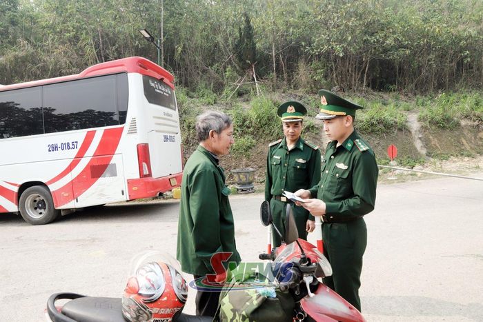 Cán bộ Trạm Biên phòng Cửa khẩu phụ Nậm Lạnh kiểm tra hộ chiếu của người dân qua cửa khẩu.
