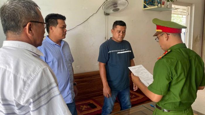 Cơ quan CSĐT Công an tỉnh Khánh Hòa tống đạt quyết định khởi tố bị can Nguyễn Thanh Bình (áo xanh đen).