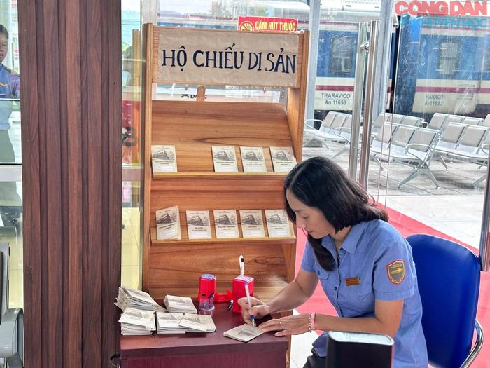 Nhân viên Ga Lào Cai ghi bút tích lên "Hộ chiếu di sản" tại Trưng bày hiện vật về 120 năm đường sắt Hải Phòng - Lào Cai - Côn Minh. Ảnh: Bảo tàng Lào Cai
