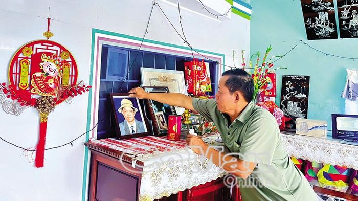 Ông Đoàn Văn Chiến lau di ảnh của liệt sĩ Đoàn Văn Út.