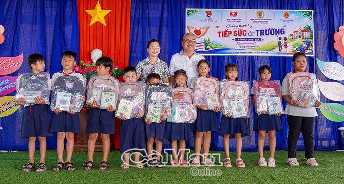 Các em học sinh nhận quà từ nhà tài trợ.
