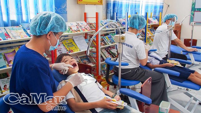 Bác sĩ Bệnh viện Răng Hàm Mặt Trung ương Thành phố Hồ Chí Minh kiểm tra tình trạng răng miệng, hướng dẫn vệ sinh răng đúng cách và tư vấn điều trị cho học sinh tại Trường Tiểu học Tân Định.