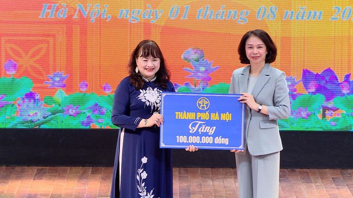 Phó Chủ tịch UBND thành phố Vũ Thu Hà trao quà của thành phố tặng Hội Khuyến học Hà Nội. Ảnh: Lê Nguyễn