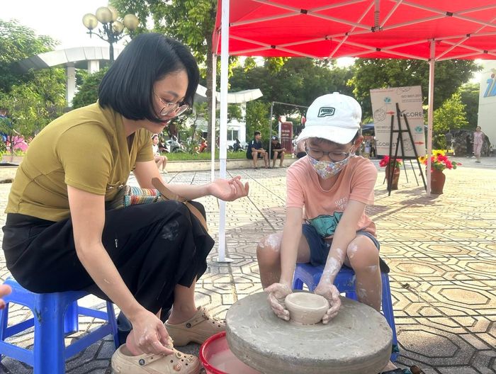 Chị Thục Anh (chung cư CT18, phường Việt Hưng) cùng con trai trải nghiệm làm gốm. Ảnh: B.Duy