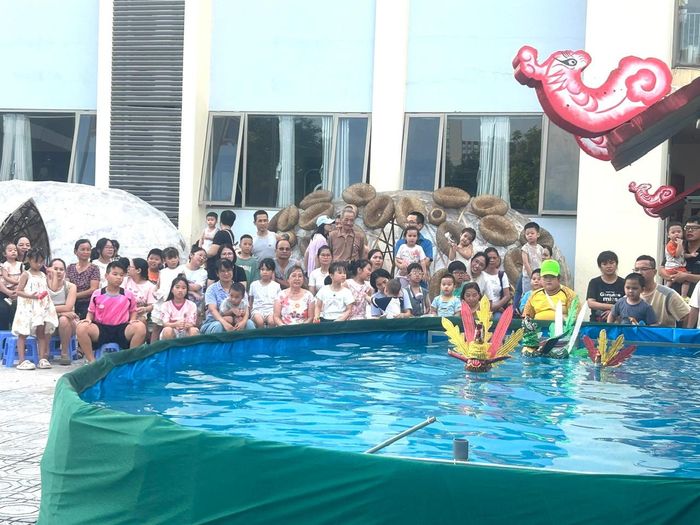Trẻ em háo hức với màn biểu diễn múa rối nước. Ảnh: B.Duy