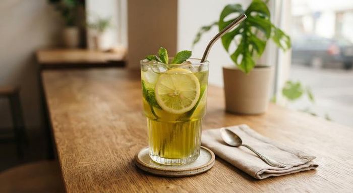 Thêm chanh vào trà xanh sẽ bổ sung thêm vitamin C và có thể hỗ trợ tiêu hóa, cung cấp nước cho cơ thể. Ảnh AI