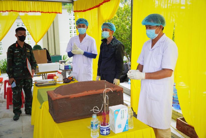 Bác sĩ Đặng Hải thắp nén tâm nhang trước khi mở nắp tiểu đã được khai quật để tìm mẫu tiểu cốt để giám định ADN. Ảnh: Nhật Thắng.