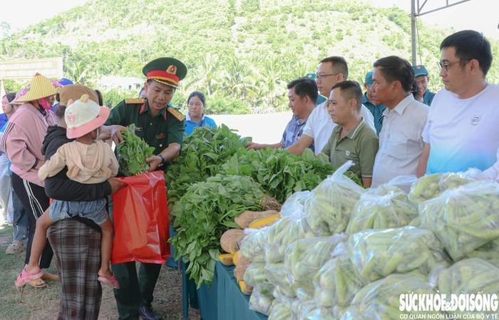 Cán bộ Ban CHQS phường Ba Ngòi cùng mạnh thường quân phát rau xanh, các loại củ quả cho người dân. Ảnh: Duy Ngọc