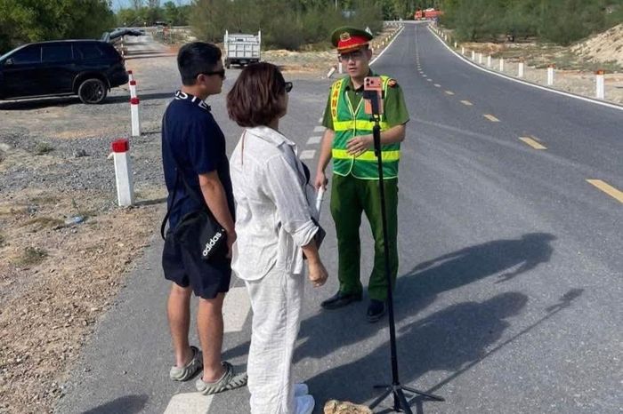  Công an xã Cam Hồng nhắc nhở du khách không đứng giữa đường chụp ảnh với cánh đồng điện gió. 