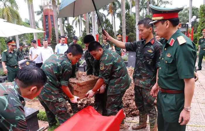 Thực hiện quy trình khai quật, đưa hài cốt liệt sĩ chưa xác định danh tính về khu vực lấy mẫu sinh phẩm tại Nghĩa trang liệt sĩ Nhổn (phường Tây Tựu). Ảnh: Văn Điệp – TTXVN
