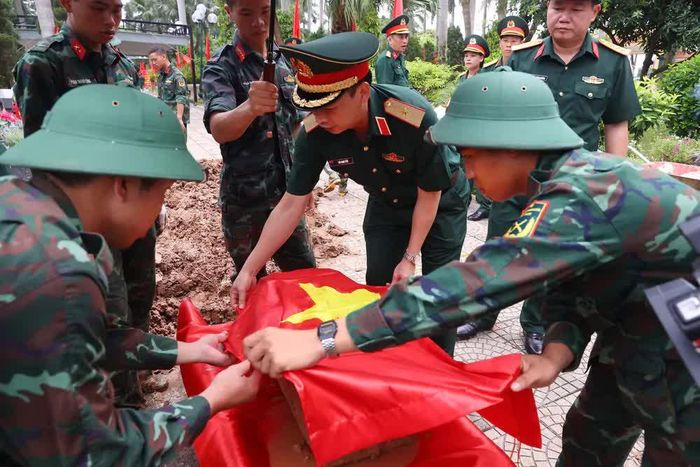 Thực hiện quy trình khai quật, đưa hài cốt liệt sĩ chưa xác định danh tính về khu vực lấy mẫu sinh phẩm tại Nghĩa trang liệt sĩ Nhổn (phường Tây Tựu). Ảnh: Văn Điệp – TTXVN