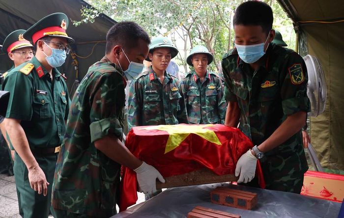 Thực hiện quy trình khai quật, đưa hài cốt liệt sĩ chưa xác định danh tính về khu vực lấy mẫu sinh phẩm tại Nghĩa trang liệt sĩ Nhổn (phường Tây Tựu). Ảnh: Văn Điệp – TTXVN