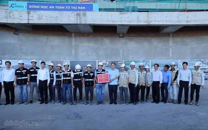 Phó Thủ tướng Thường trực Chính phủ Phạm Gia Túc tặng quà cán bộ, kỹ sư, người lao động đang thi công dự án Trung tâm tổ chức Hội nghị APEC - Ảnh: VGP/Phương Nguyên