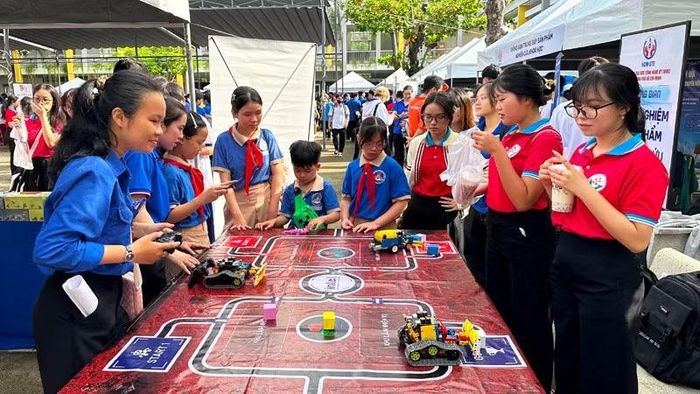 Các cháu học sinh tiểu học trải nghiệm hoạt động điều khiển robot tại ngày hội.